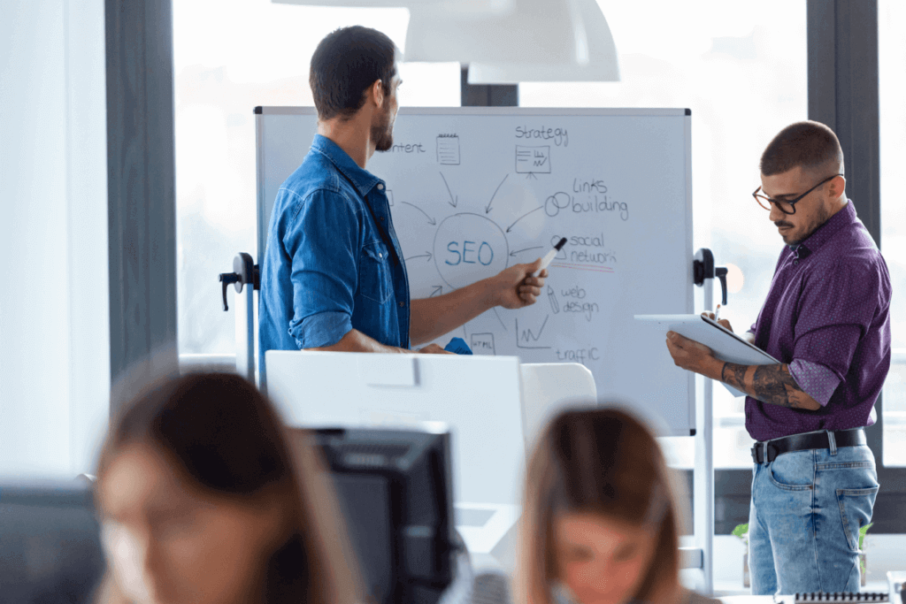 Our SEO Consultants at our SEO Agency working on an SEO strategy using a whiteboard with an SEO diagram.