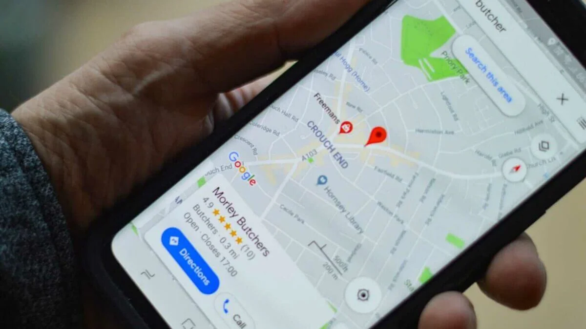 a person from our seo agency in Vietnam, holding black smartphone with local seo map directions.