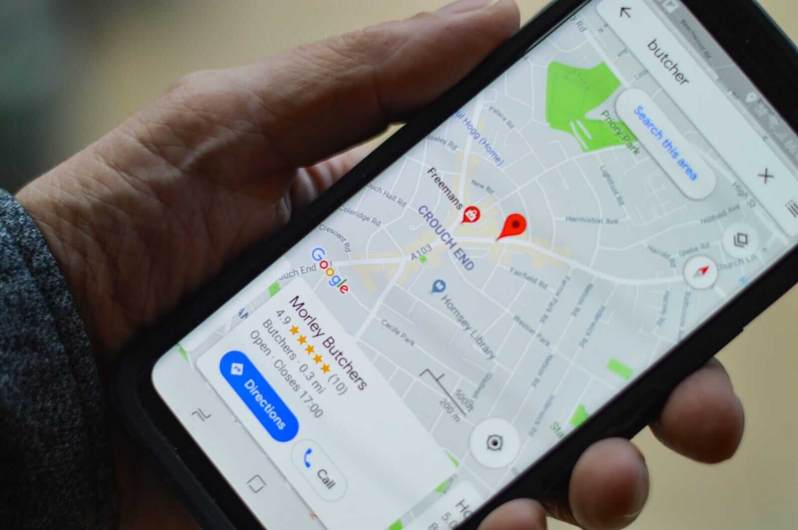 a person from our seo agency in Vietnam, holding black smartphone with local seo map directions.