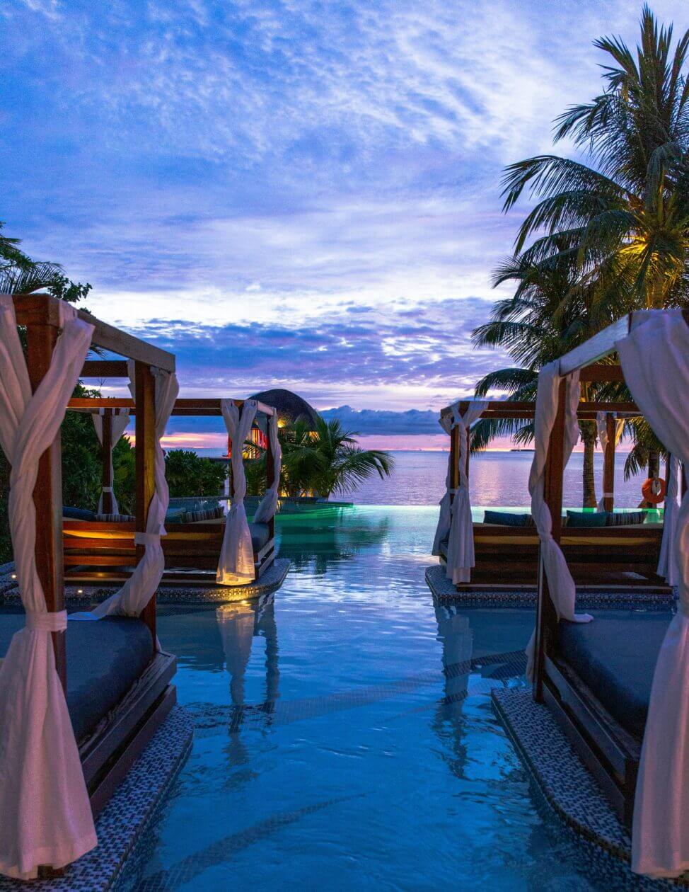 hotel website design company in vietnam taking photo showing beautiful sunset and lounge beds by the pool.