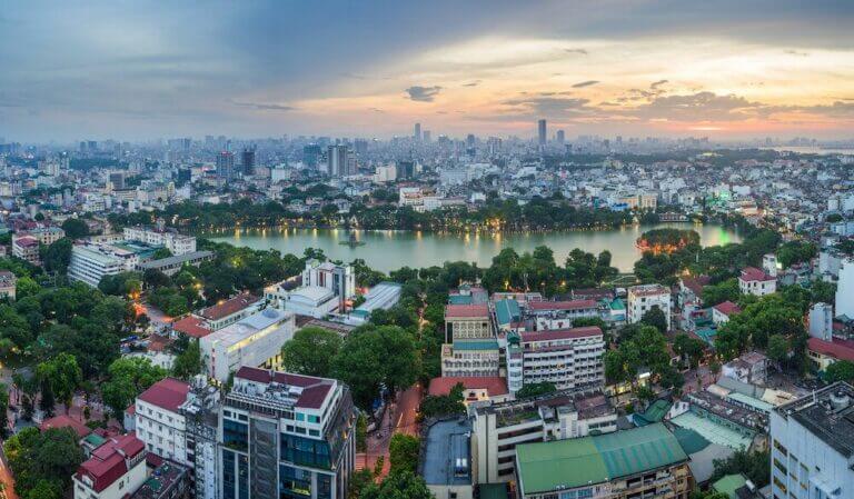 Hanoi City at sundown with an aeriel view over Hoan Kiem lake.