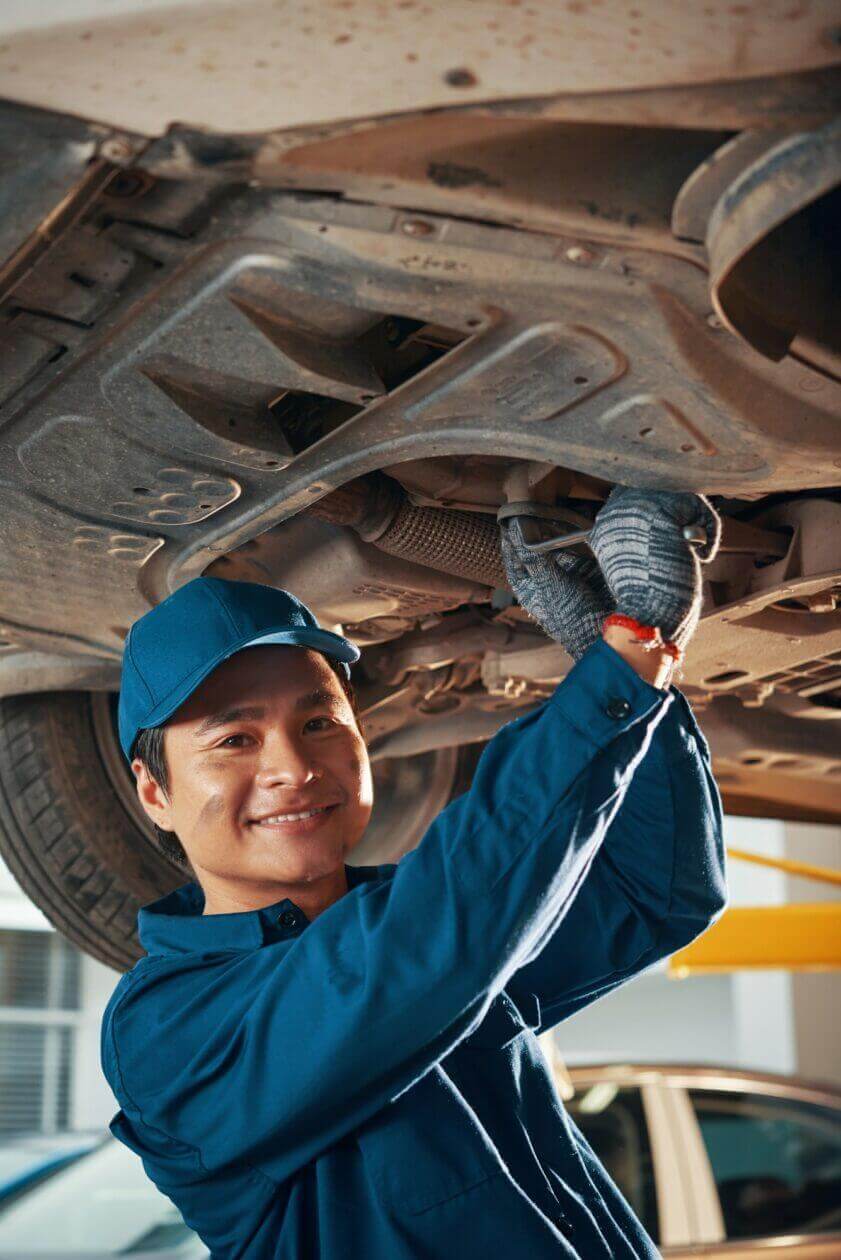A cheerful car mechanic fixing a car is a good option for local seo services