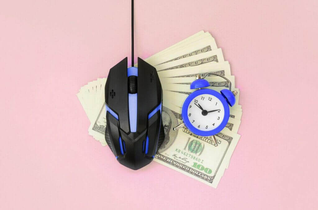 Computer mouse and small violet alarm clock on many dollar bills as an analogy for PPC services In vietnam.