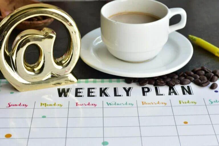 a social media marketing plan with a cup of tea and a golden @ sign.