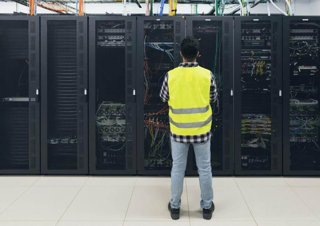Male engineer working inside our website hosting server room database in Vietnam.