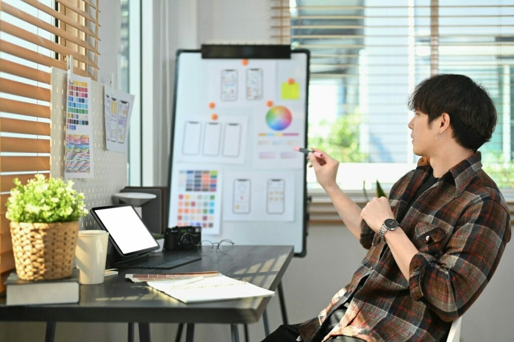 Image of creative male web designer planning application development for web mobile phone.