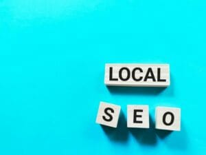 Local seo concept on wooden cubes against aqua blue background.